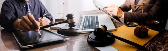 Business and lawyers discussing contract papers with brass scale on desk in office. Law, legal services, advice, justice and law concept picture with film grain effect photo