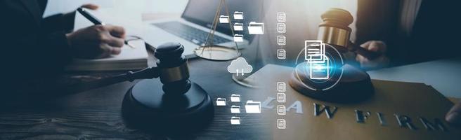 Justice and law concept.Male judge in a courtroom with the gavel, working with, computer and docking keyboard, eyeglasses, on table in morning light photo