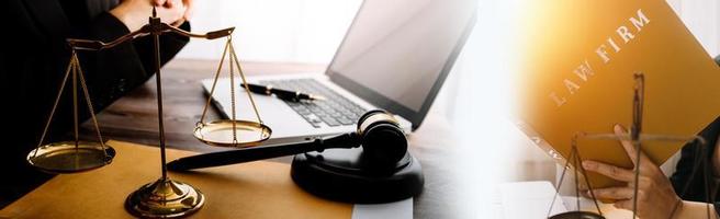 Justice and law concept.Male judge in a courtroom with the gavel, working with, computer and docking keyboard, eyeglasses, on table in morning light photo