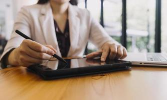 hombre de negocios y equipo analizando la tarea financiera de los estados financieros. con teléfono inteligente y computadora portátil y tableta. concepto de gestión de riqueza foto