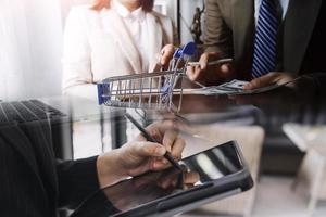 hombre de negocios y equipo analizando la tarea financiera de los estados financieros. con teléfono inteligente y computadora portátil y tableta. concepto de gestión de riqueza foto