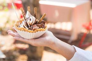 Closeup of ice cream held in hand by cute girl photo