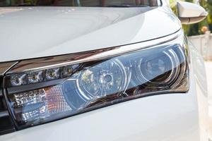 Closeup headlights of modern white car with LED daylight running lights photo