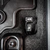 Close up hand switch of car fuel tank and hood. Car interior photo