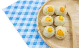 Chinese Pastry Mung Bean or Mooncake with Egg Yolk on wooden dish and spoon striped cloth photo