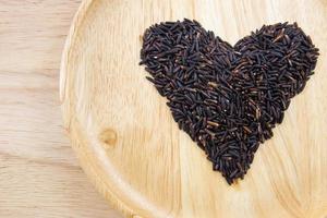 Heart rice berry in wooden bowls on wooden background. concept photo