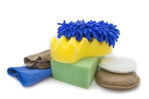 Yellow, green sponges and blue mitts for washing and microfiber fabric with cleaner cloth on white background