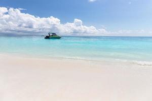 Boat on clear sea and sand with blue sky background in Phuket, Thailand photo