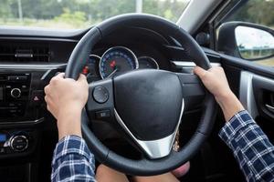 Close-up Of Woman's Hand Holding Steering Wheel for car driver photo