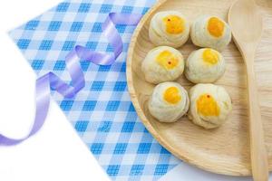 Chinese Pastry Mung Bean or Mooncake with Egg Yolk on wooden dish and spoon striped cloth ribbon photo