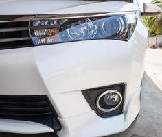 Closeup headlights of modern white car with LED daylight running lights photo