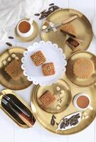 Mooncake Chinese Traditional Pastry,  Moon Cake with Tea Cups on White Wooden Background for Mid Autumn Festival photo