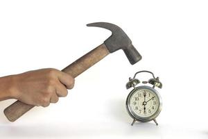 Hand of men holding a hammer to smash the alarm clock isolated on white background included clipping path. photo