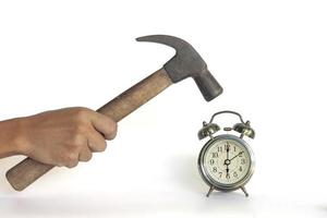 Hand of men holding a hammer to smash the alarm clock isolated on white background included clipping path. photo