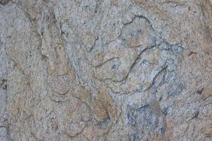 la superficie de la piedra en la orilla del mar se arrastra al agua del mar durante mucho tiempo en busca de fondos y texturas. foto