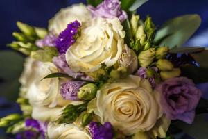 bright wedding bouquet of summer white violet roses  with wedding rings photo