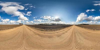 panorama hdri esférico completo sin costuras vista en ángulo de 360 grados en camino de grava entre campos en primavera con impresionantes nubes en proyección equirectangular, listo para contenido de realidad virtual vr ar foto