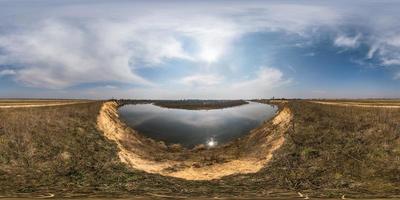 full seamless spherical hdri panorama 360 degrees angle view on coast of huge river or lake in spring day with awesome clouds in equirectangular projection, ready for VR AR virtual reality content photo