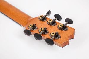 Clavijas de afinación en la cabeza de la máquina de madera de guitarra de seis cuerdas sobre fondo blanco. foto