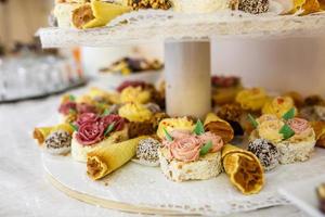 View of the served for decorated wedding dinner candy bar table with different sweet treats photo