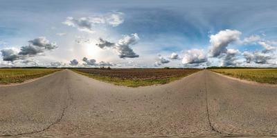 panorama hdri esférico completo sin costuras vista en ángulo de 360 grados en la antigua carretera asfaltada entre campos en el día de otoño con impresionantes nubes en proyección equirectangular, listo para contenido de realidad virtual vr ar foto