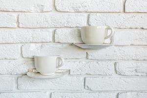 coffee cups as lamp decorations on a white brick wall in modern loft cafe photo