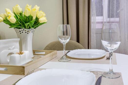 primer plano de copas de vino vacías en la mesa del banquete con cubiertos y ramo de flores de tulipán amarillo foto