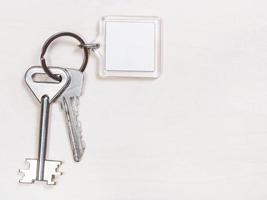 two door keys on keyring with blank white keychain photo