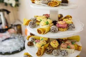 View of the served for decorated wedding dinner candy bar table with different sweet treats photo