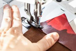 dressmaker sewing leather on sewing machine photo