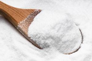 above view of wooden spoon with dextrose on pile photo