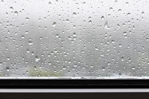 raindrops and trickles of rain close up on window photo