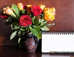blank desk calendar and fresh red and yellow roses photo