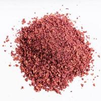 pile of ground sumac spice close up on gray photo