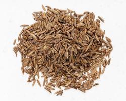 top view of pile of caraway seeds close up on gray photo