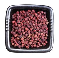 dried magnolia berries in black bowl isolated photo