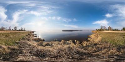 full seamless spherical hdri panorama 360 degrees angle view on coast of huge river or lake in spring day with awesome clouds in equirectangular projection, ready for VR AR virtual reality content photo