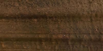 view from above on surface of gravel road with car tire tracks photo