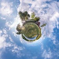 pequeño planeta transformación de panorama esférico 360 grados. vista aérea abstracta esférica en el campo en una agradable velada con impresionantes nubes hermosas. curvatura del espacio. foto