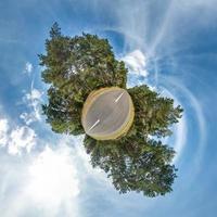 Little planet transformation of spherical panorama 360 degrees. Spherical abstract aerial view in field in nice evening with awesome beautiful clouds. Curvature of space. photo