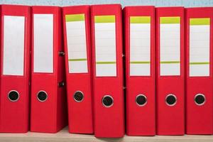 row of folders for papers and documentation on a shelf in the office photo