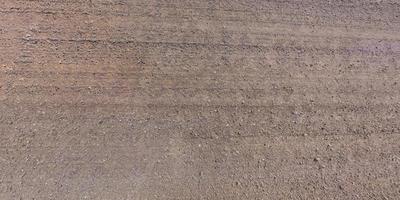 view from above on surface of gravel road with car tire tracks photo