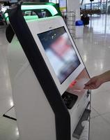 Self check in machine and help desk kiosk at Bangkok International Airport for check in, printing boarding pass or buying ticket photo