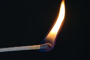 A selective focus of a match on fire on black background photo