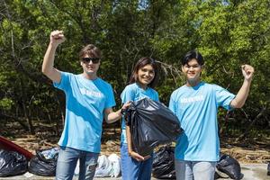 equipo de jóvenes y diversos grupos de trabajadores voluntarios disfrutan del trabajo social caritativo al aire libre en la limpieza del proyecto de separación de basura y desechos en el bosque de manglares foto