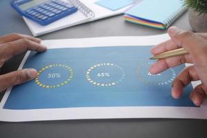 man hand with pen analyzing financial data pov photo