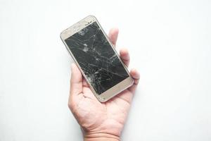 mano de hombre sosteniendo un teléfono inteligente roto sobre fondo blanco foto