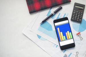 top view of financial chart display on smart phone on table photo