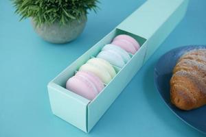 macaroon in a paper box on light green background photo