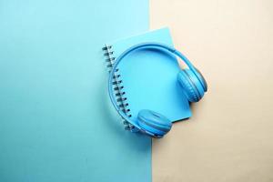 Audio book concept. Headphones and notepad on table photo